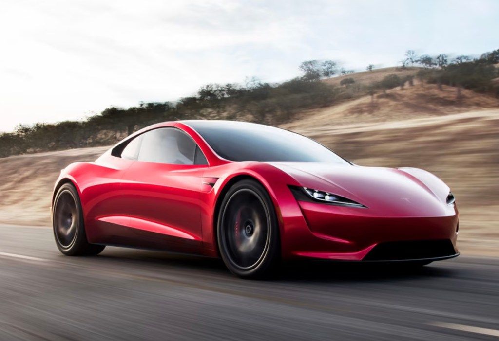 Xe Tesla Roadster thế hệ thứ hai màu đỏ đang chạy trên đường, biểu tượng cho tầm nhìn táo bạo của Tesla.