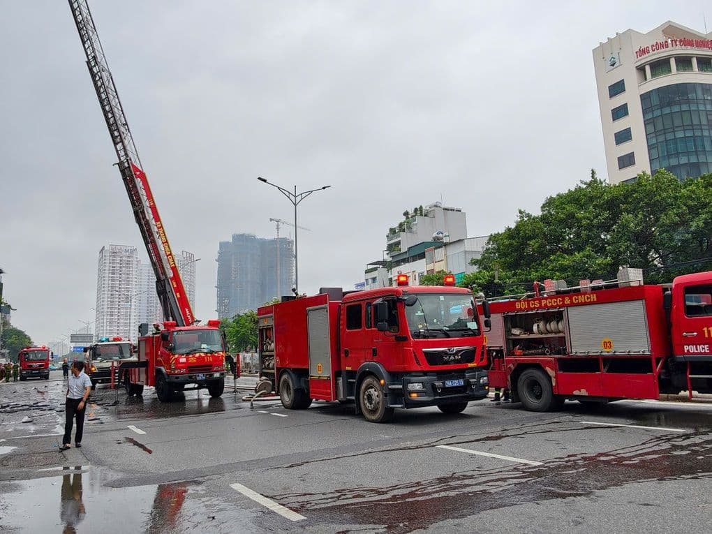 Xe thang và xe cứu hỏa của lực lượng PCCC tại hiện trường vụ cháy trên đường Giải Phóng trong điều kiện thời tiết mưa bão