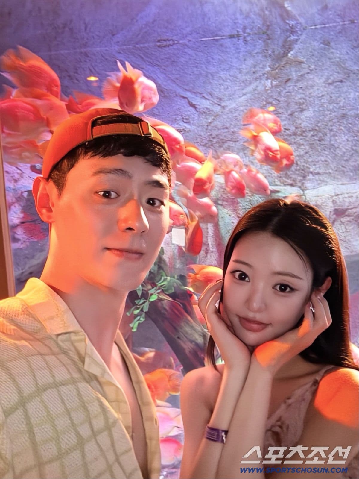Yoo Si Eun và Lee Gwan-hee chụp ảnh selfie thân mật bên bể cá, tượng trưng cho tình yêu nảy nở từ những khoảng lặng.